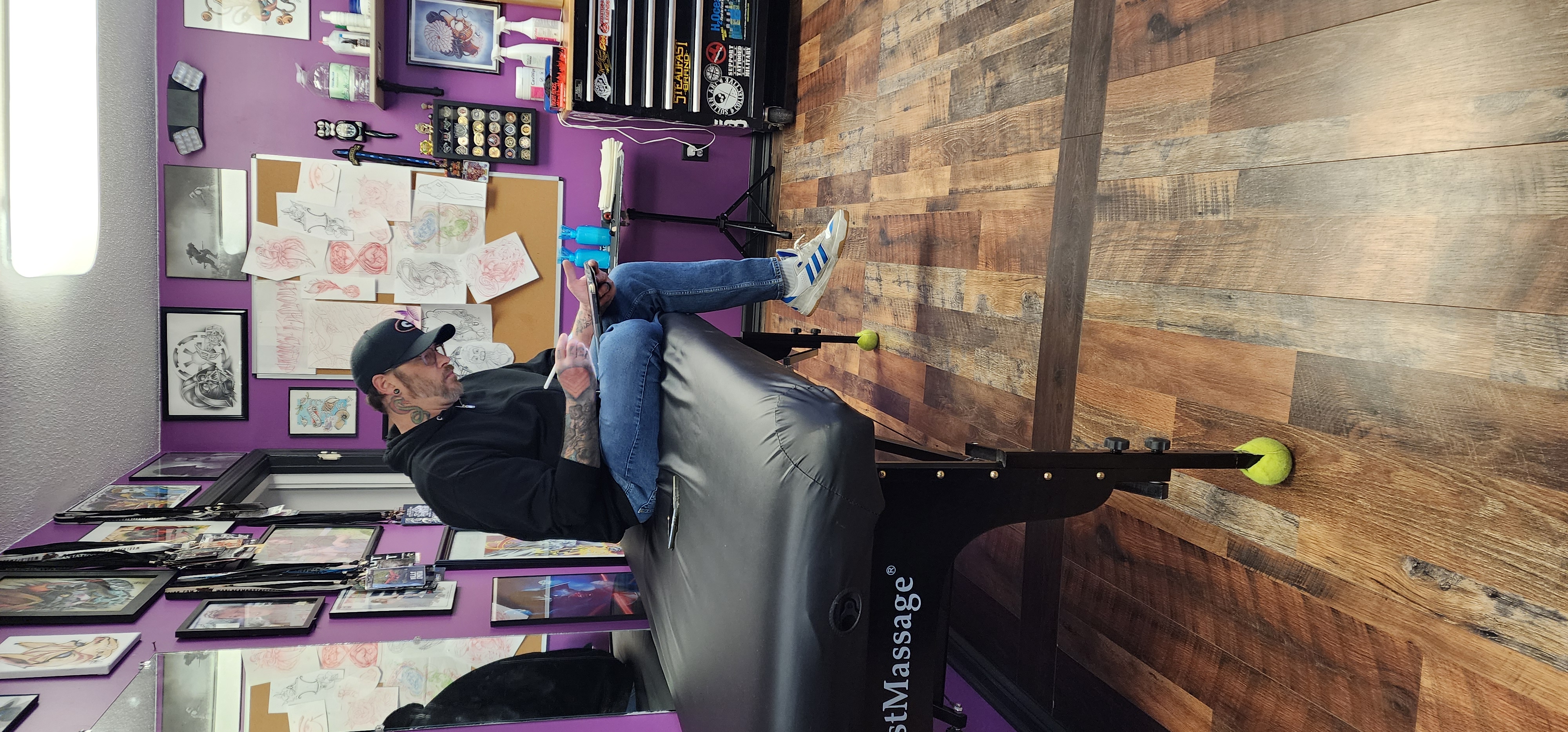 Billy Smith drawing a tattoo design on a tablet in the studio