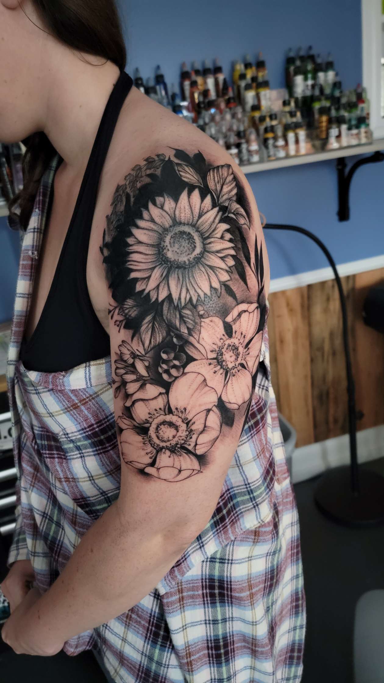 Black and grey sunflower and floral upper-arm tattoo by Billy Smith